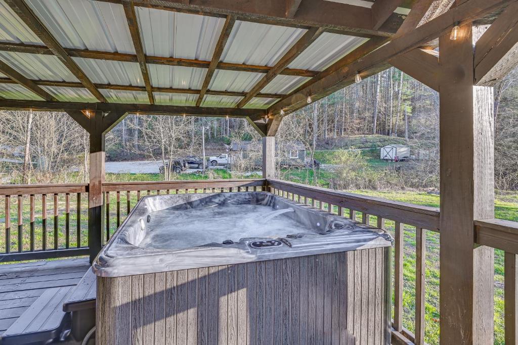 a hot tub on a deck with a roof at Cabin with Expansive Deck about 4 Mi to Red River Gorge! in Rogers