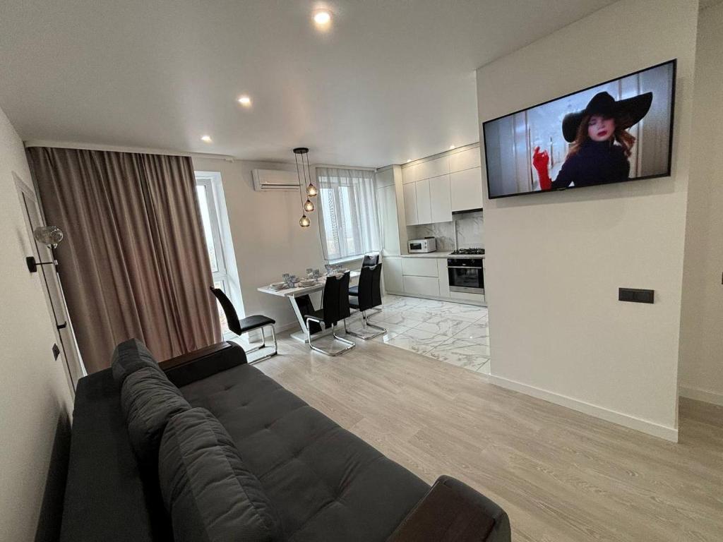 ein Wohnzimmer mit einem Sofa und einem TV an der Wand in der Unterkunft Апартаменти класу люкс в ЖК Яровиця,1 спальня in Luzk