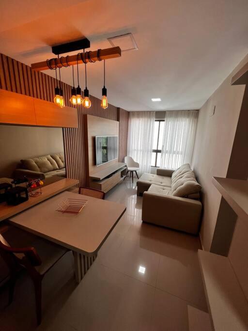 een woonkamer met een bank en een tafel bij Flat completo e aconchegante in Recife
