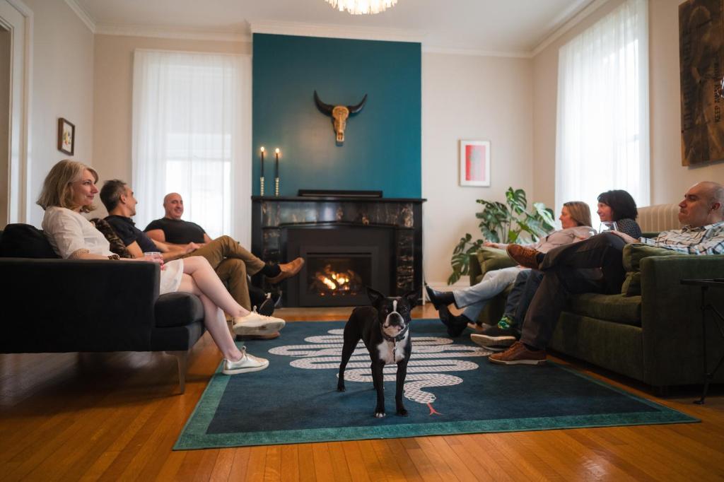 a group of people sitting in a living room with a dog at Canandaigua Guesthouse in Canandaigua
