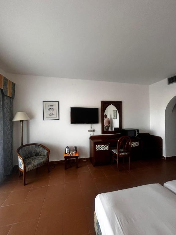 Schlafzimmer mit einem Bett, einem Schreibtisch und einem TV in der Unterkunft appartamento nel resort Domina in Sharm El Sheikh