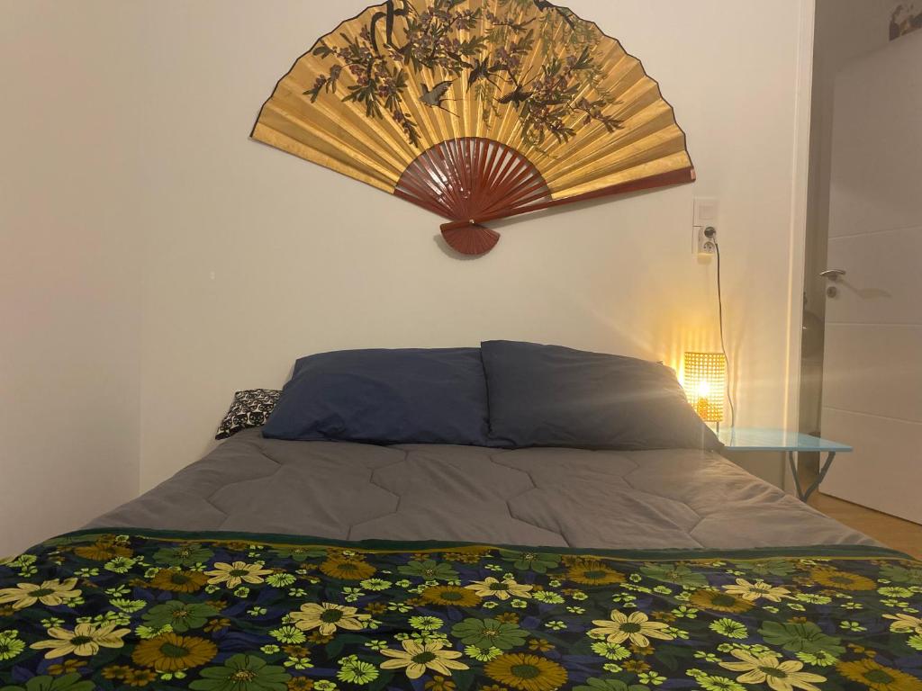 a bedroom with a bed with a fan on the wall at Paris-Versailles-Cosy-Calme-WIFI in Paris