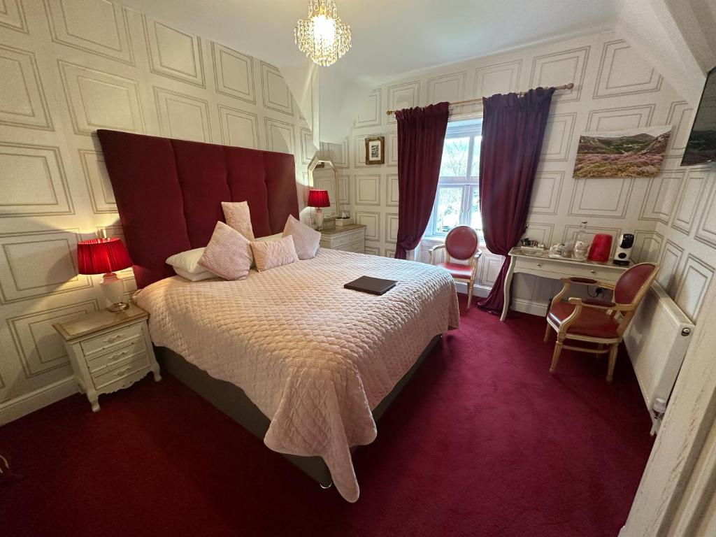 a bedroom with a large bed with a red carpet at The Courthouse in Betws-y-coed