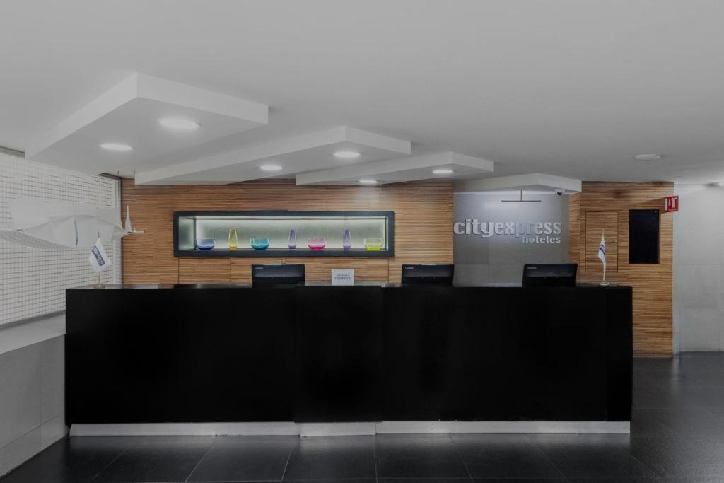 a lobby with a large black desk with chairs at City Express by Marriott Ciudad de México Alameda in Mexico City