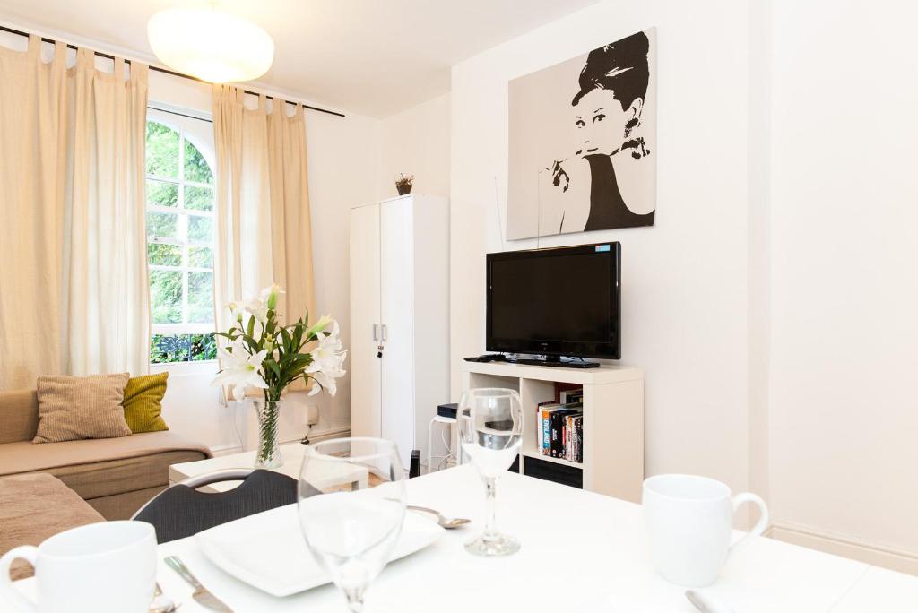 ロンドンにあるModern Luxury flatの白いリビングルーム(テーブル、テレビ付)