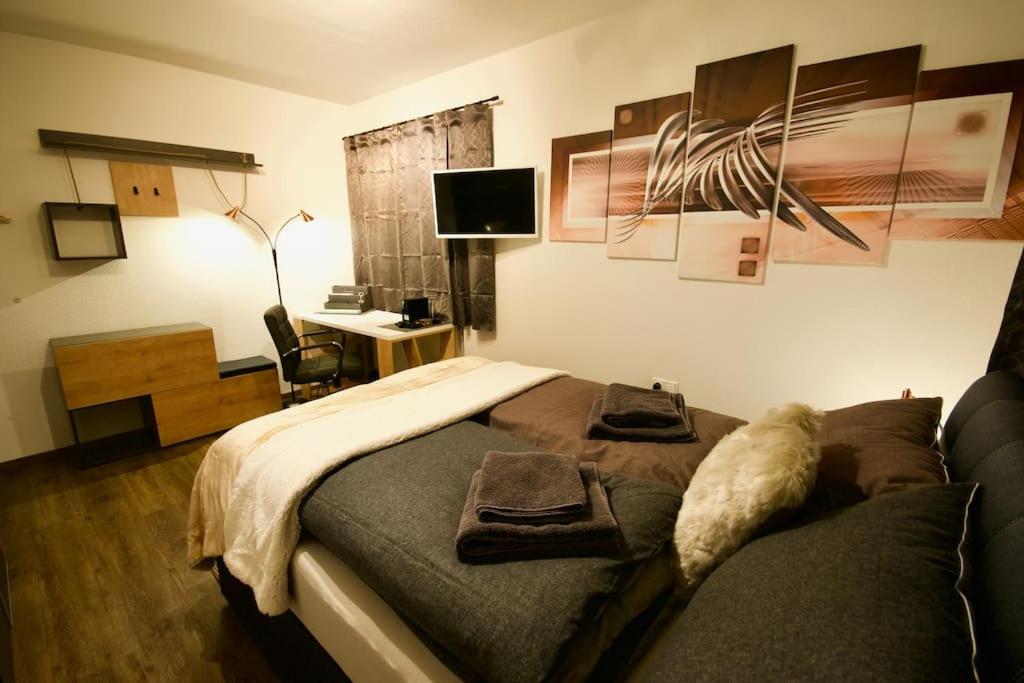 a bedroom with a bed and a desk with a computer at Serviced Business Apartment in Lorsch