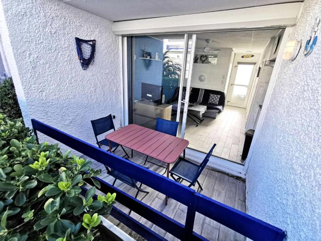 un patio avec une table et des chaises sur un balcon dans l'établissement Résidence Etoile Du Sud - 2 Pièces pour 4 Personnes 401, à Leucate