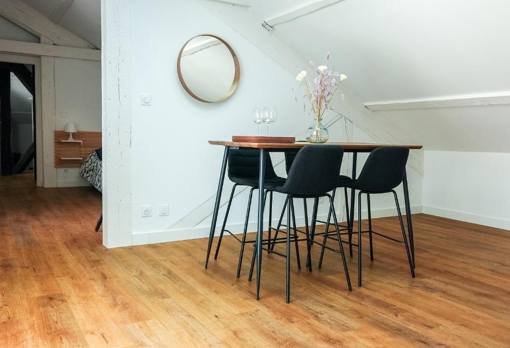 stół i krzesła w pokoju z lustrem w obiekcie Appartement neuf climatisé tout équipé 2 à 4 couchages w Béziers