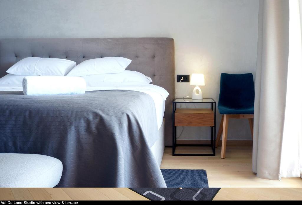 a bedroom with a bed and a blue chair at Val De Laco studio apartments in Rovinj