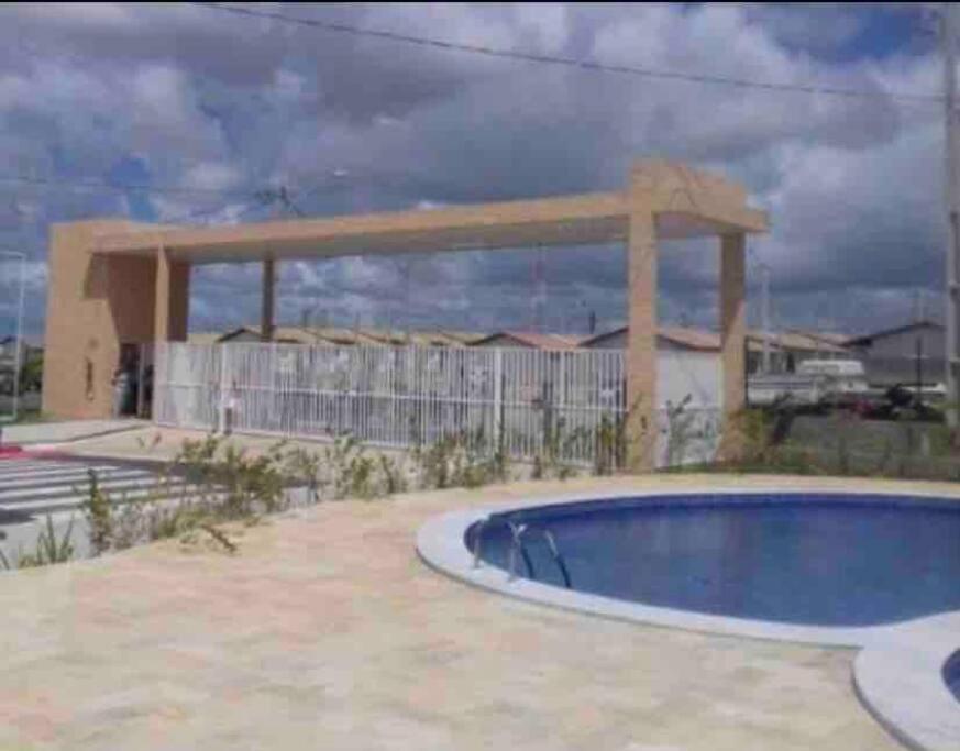une piscine en face d'un bâtiment dans l'établissement Casa Aeroporto Maceió Palmeiras, à Maceió