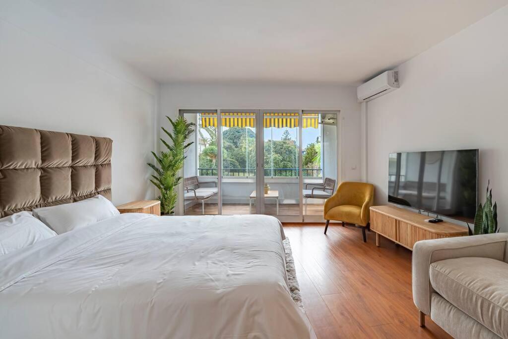- une chambre avec un lit, un canapé et une télévision dans l'établissement Elegant Studio with Balcony, Pool & Parking, à Marbella