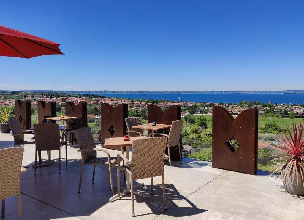 un patio con tavoli e sedie e vista di Hotel Castello S. Antonio a Lazise