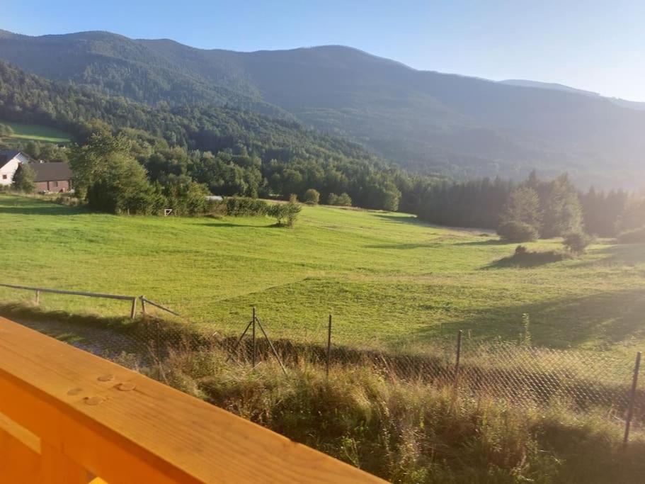 un campo de césped verde con montañas en el fondo en Panorama Sucha Góra ,Leśny domek, en Skawica