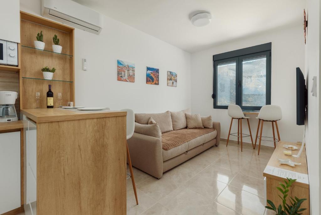 uma sala de estar com um sofá e uma mesa em DM Apartments em Kotor