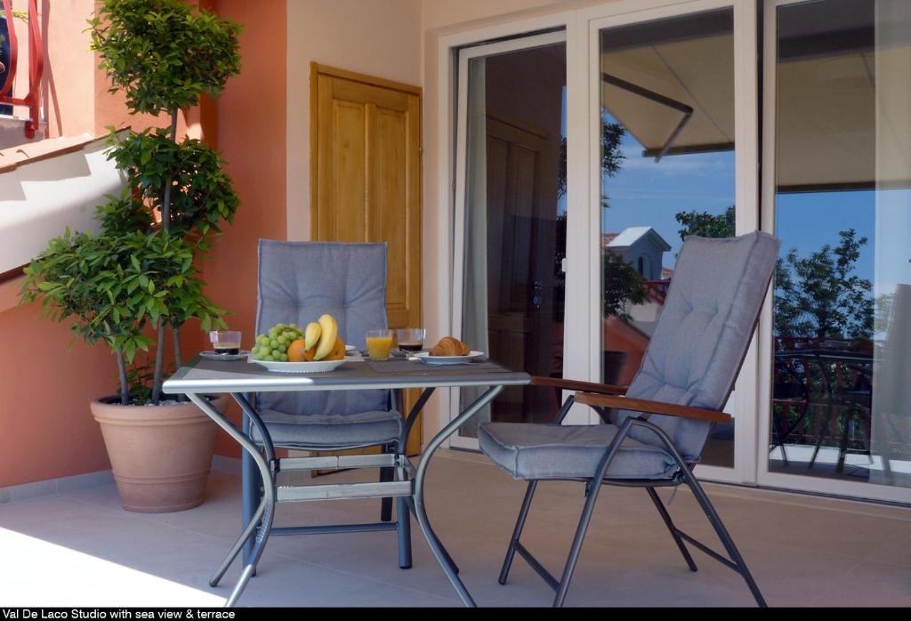 a table and two chairs with a bowl of fruit on it at Val De Laco studio apartments in Rovinj