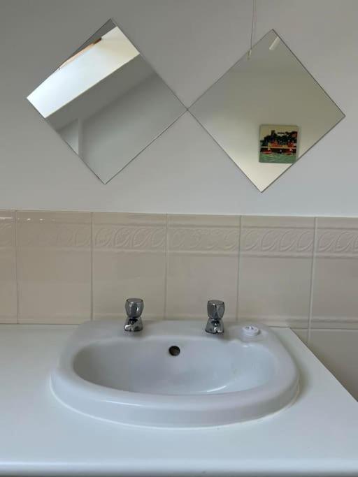 a white sink in a bathroom with a mirror at Annie's Hideaway in Chapel Saint Leonards