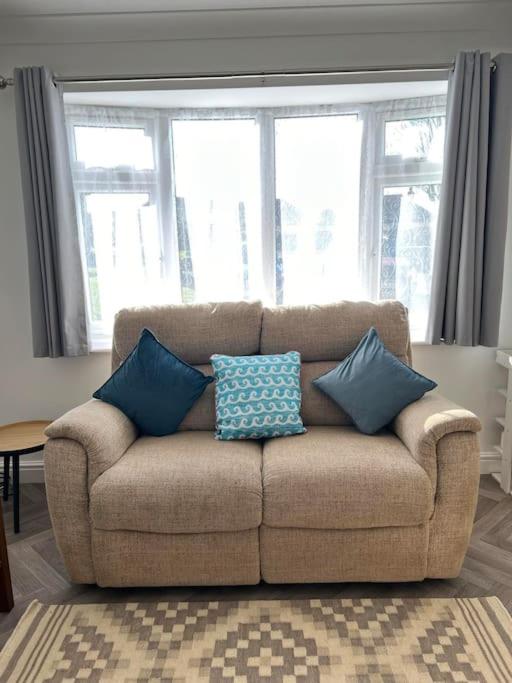 a couch with pillows on it in a living room at Annie's Hideaway in Chapel Saint Leonards