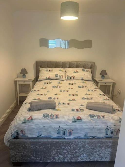 a bed in a bedroom with two night stands at Annie's Hideaway in Chapel Saint Leonards