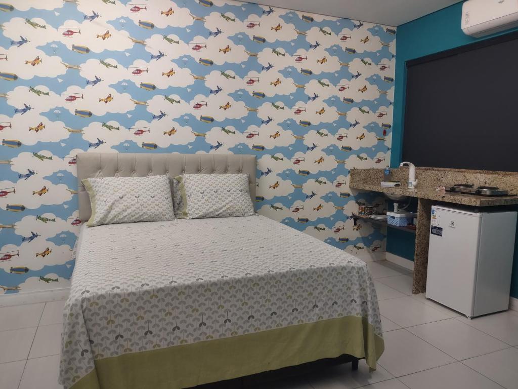 1 dormitorio con 1 cama con una pared cubierta de cerdos en Quarto Nostalgia, en Rio Branco