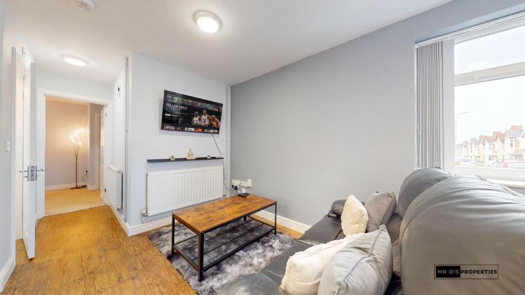 ein Wohnzimmer mit einem Sofa und einem Tisch in der Unterkunft Cardiff centre flat with free parking in Cardiff