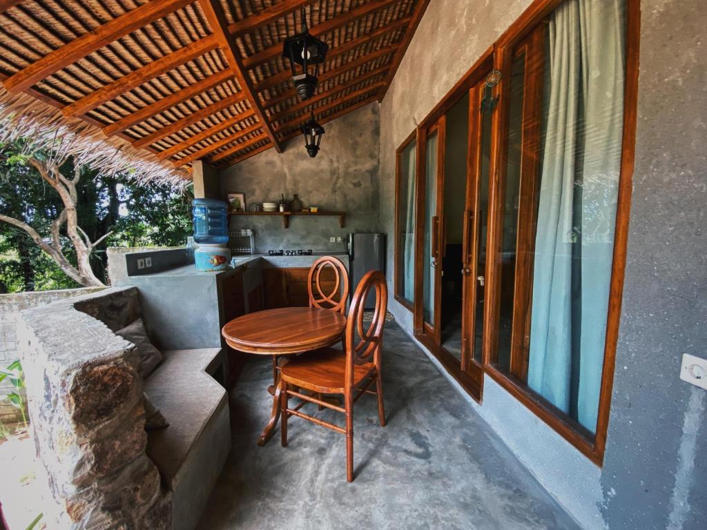 een tafel en twee stoelen op een veranda bij Basa-basi Lodge in Karimunjawa