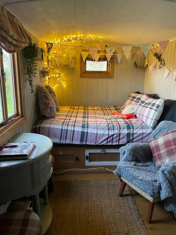a room with two beds and a couch in it at Oakley View Shepherds Hut with hot tub in Whitby