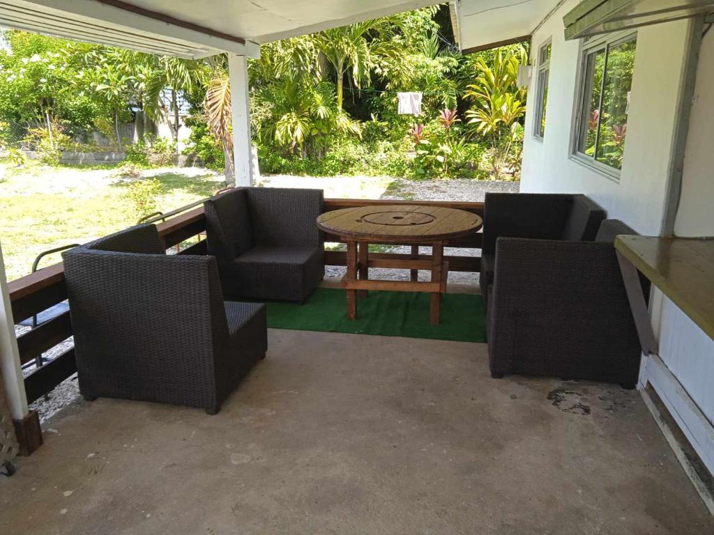 a patio with a table and chairs on a porch at Chez Angele in Faie