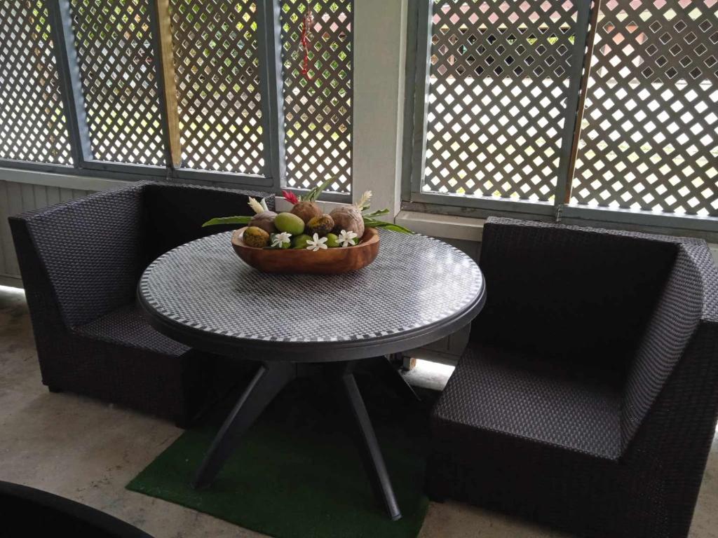 a table with a bowl of fruit on it next to two chairs at Chez Angele in Faie