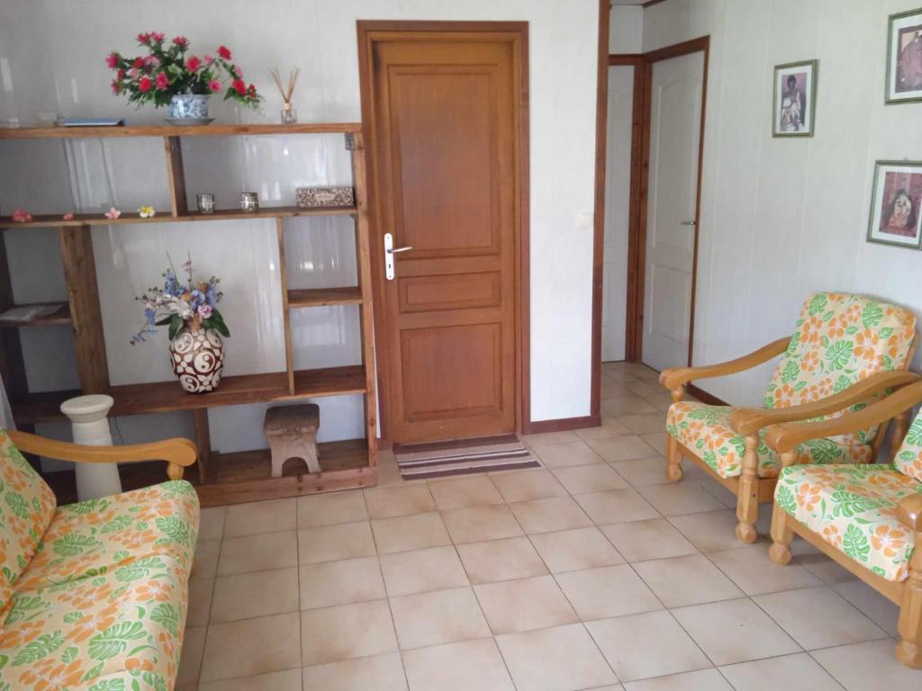 a living room with two chairs and a door at Chez Angele in Faie