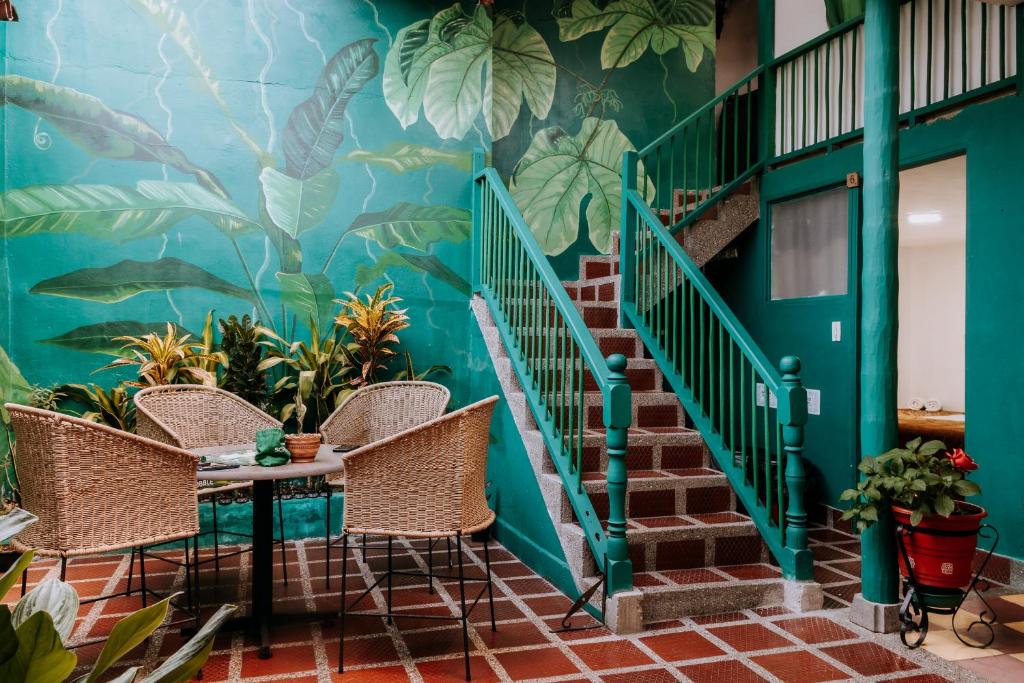a room with stairs and a mural of plants at Origen Hostel Jardín in Jardin