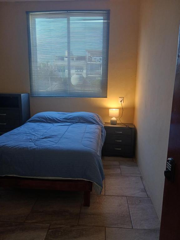 a bedroom with a bed and a window at POSADA Diamante in Puerto Escondido