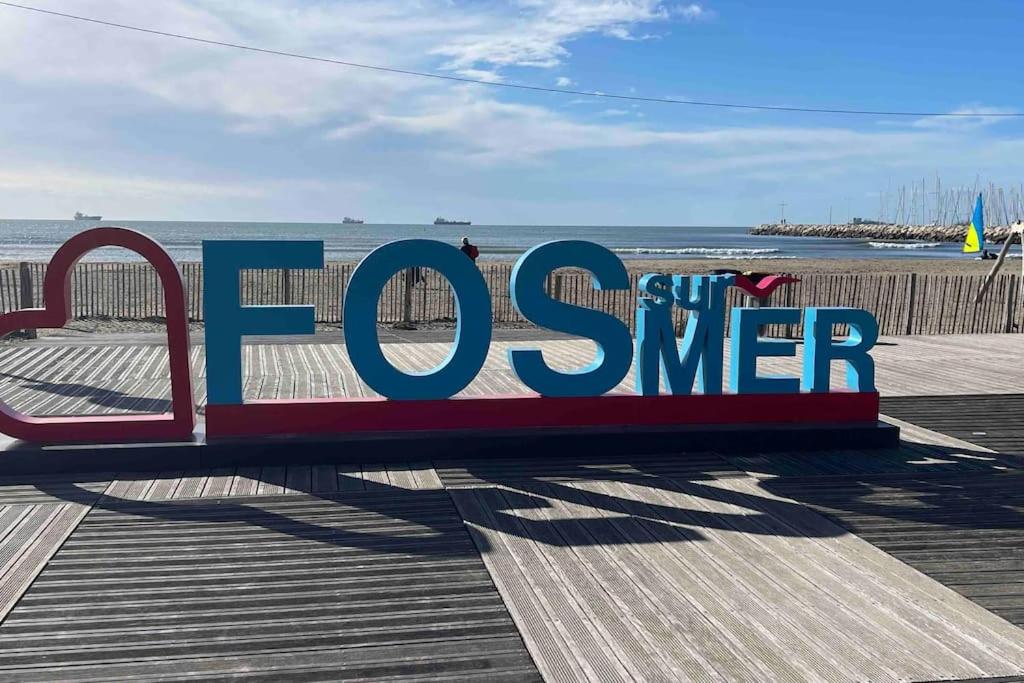 un panneau sur une jetée à côté de la plage dans l'établissement Appartement sur la plage, à Fos-sur-Mer