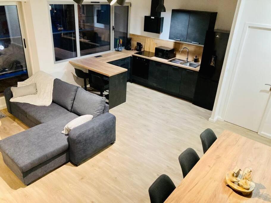a living room with a couch and a table at Duplex au cœur de Béthune 3 étoiles in Béthune