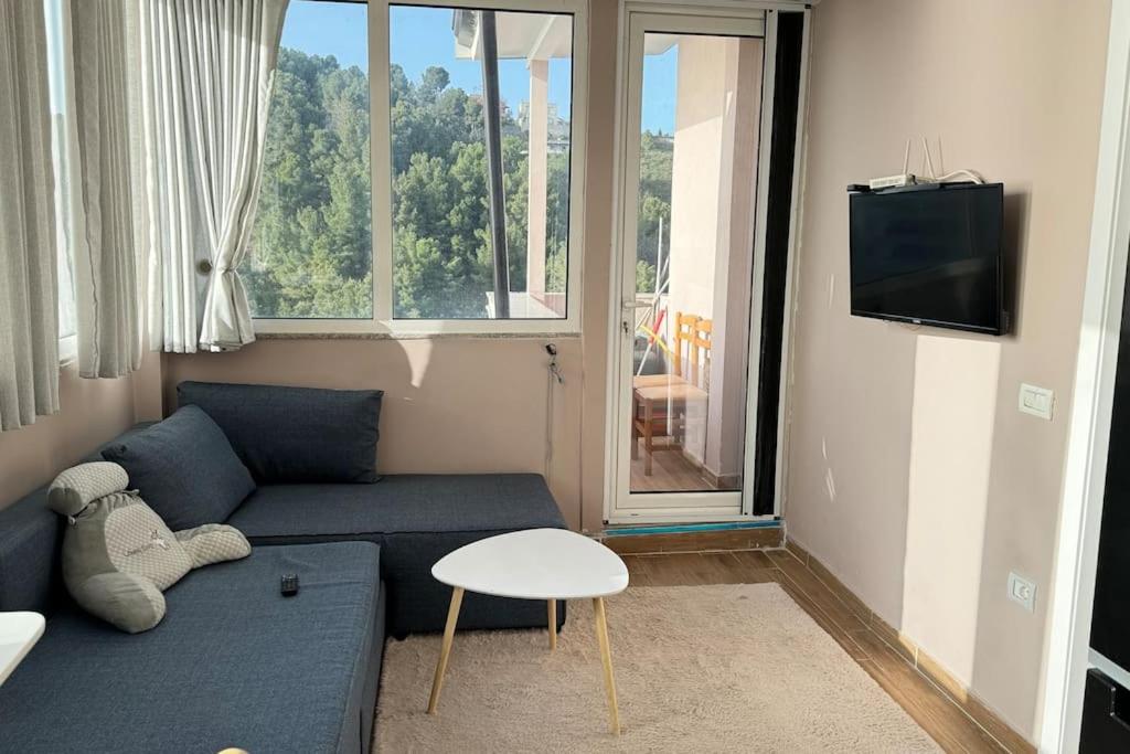 - un salon avec un canapé bleu et une fenêtre dans l'établissement BS Apartment 5, à Durrës