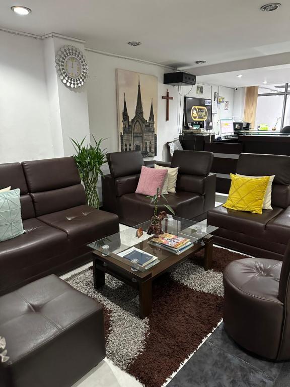 uma sala de estar com sofás e uma mesa de centro em Hotel Royal Suite em Manizales