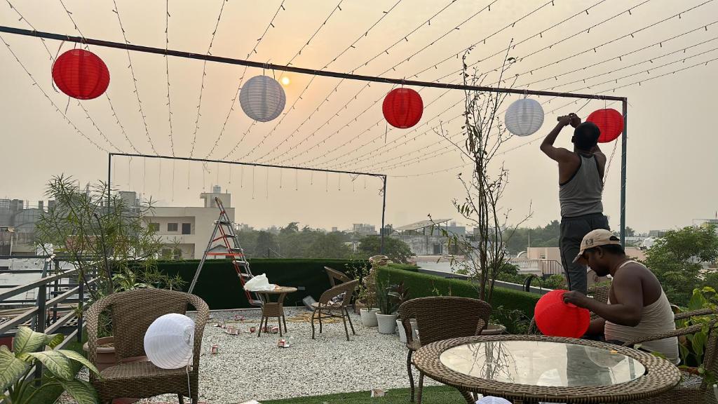 two people playing with paper lanterns on a patio at The Grey House! in Noida