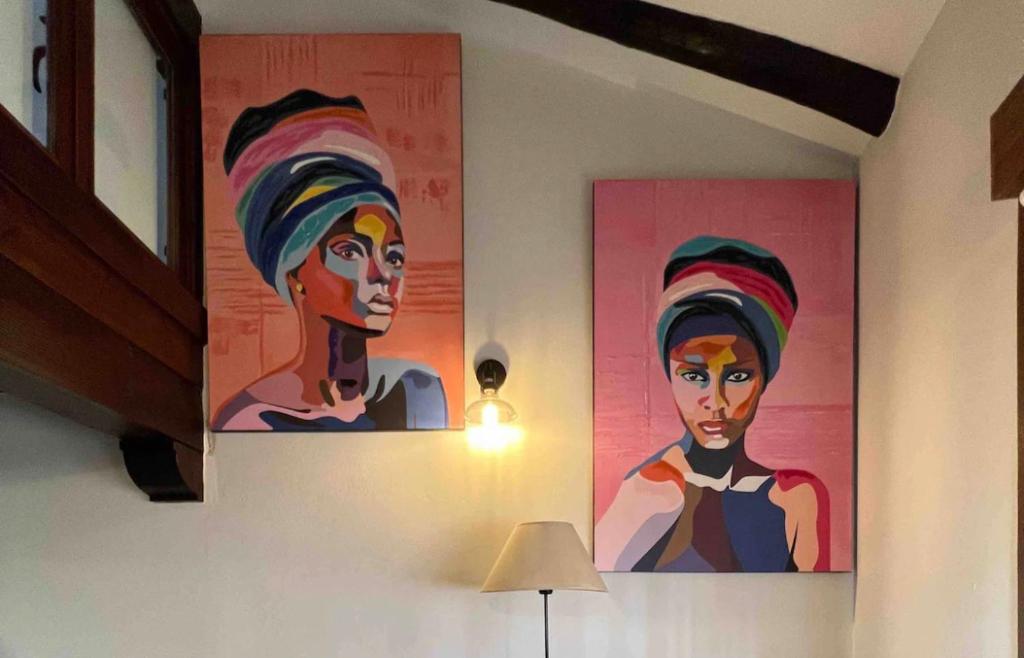 two paintings of a woman on a wall at Apartamento dúplex en Sangüesa de 3 dormitorios y 2 baños in Sangüesa