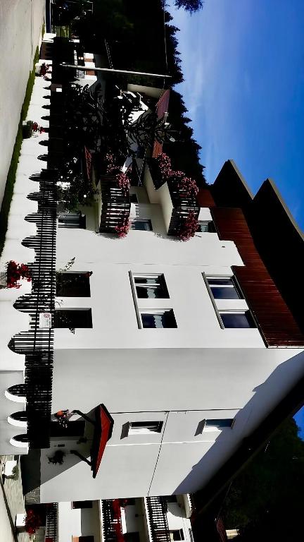 un edificio alto de color blanco con balcones en un lateral. en Maggioni Silvia en Tarvisio