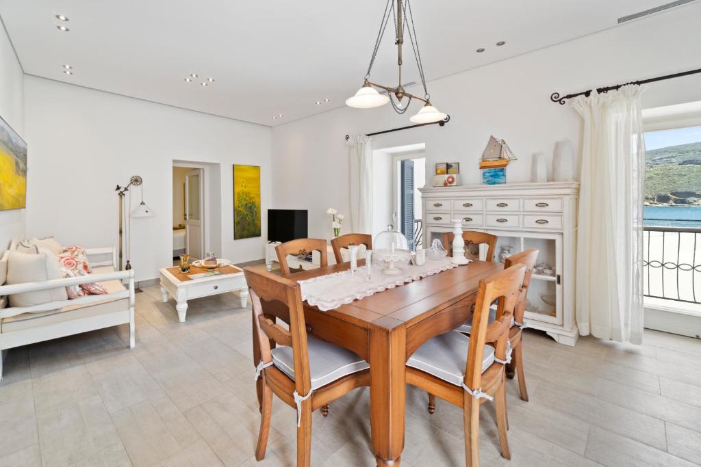 uma sala de jantar com mesa e cadeiras em Seafront, Luxury 2-BDR Townhouse em Andros