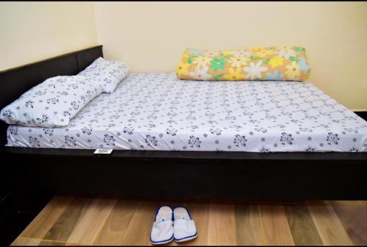 uma cama com duas almofadas e um par de sapatos em Blissfulgetaway em Thika