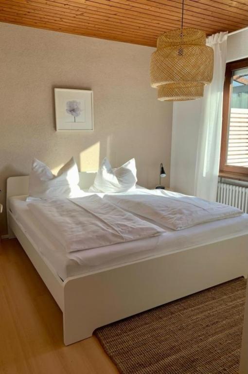 a bedroom with a bed with white sheets and pillows at Haus Delbar in Bodman-Ludwigshafen