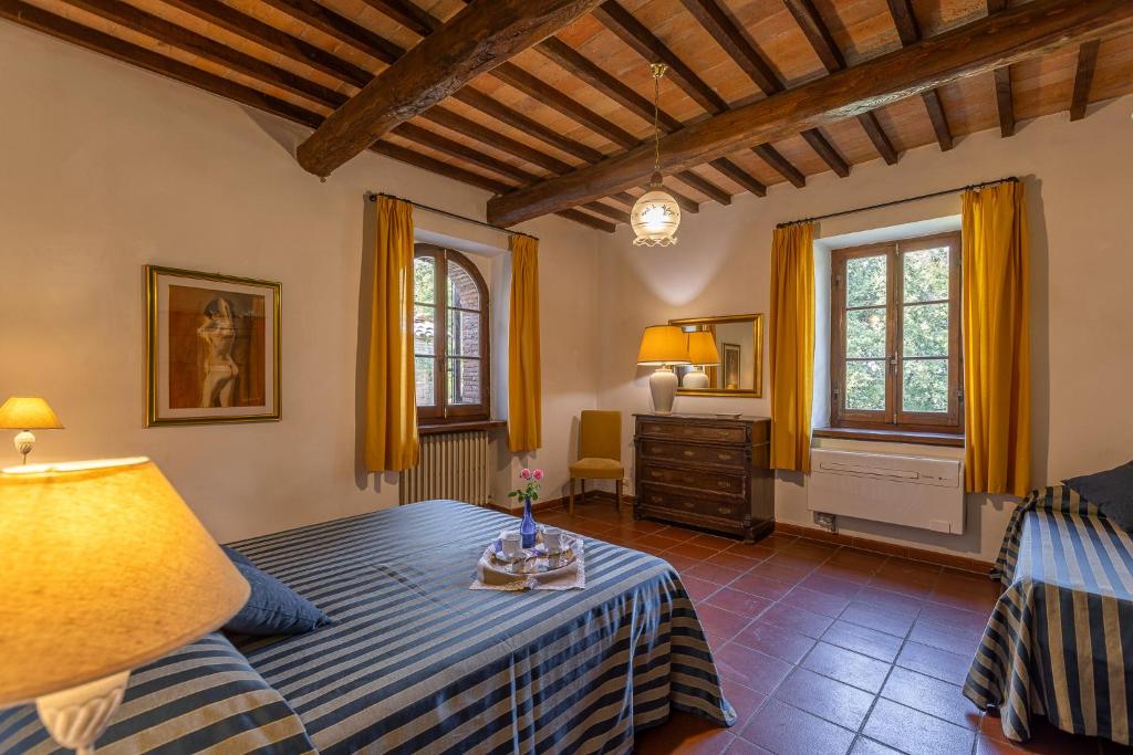 a bedroom with a bed and a table in a room at Villa Palazzo Bello con piscina e AC - Cetona in Cetona