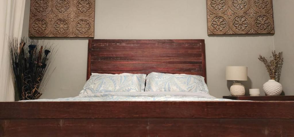 a bed with a wooden headboard and two pillows at Miami - Brickell - Beaches in Miami