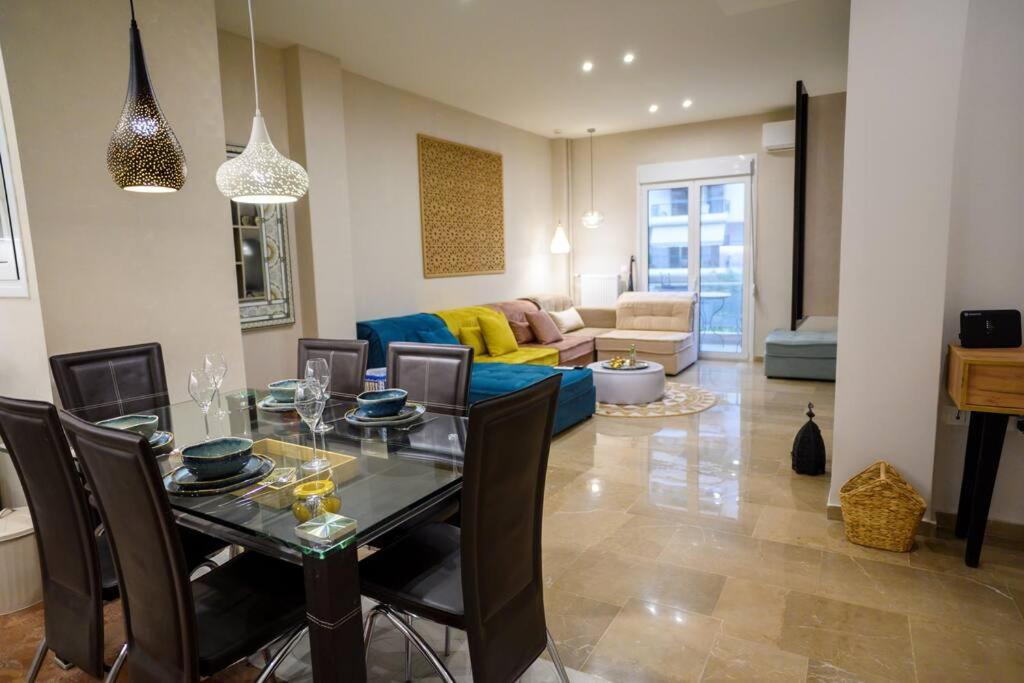 uma sala de estar com uma mesa de jantar e um sofá em Boho 2 bdr luxury meets the East em Atenas