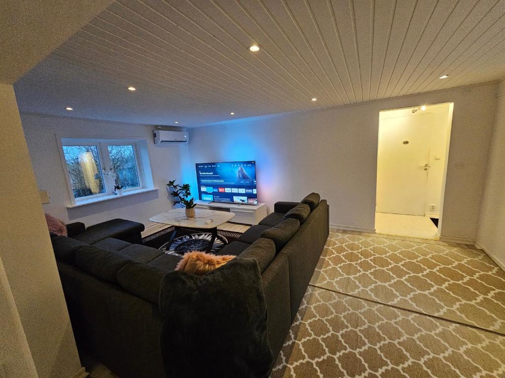 een woonkamer met een bank en een tv bij Relax Place in Svalöv