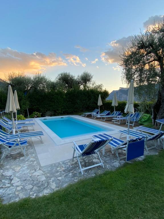 a swimming pool with lounge chairs and umbrellas at Villa Gaia appartamenti con piscina Seeblick in Malcesine