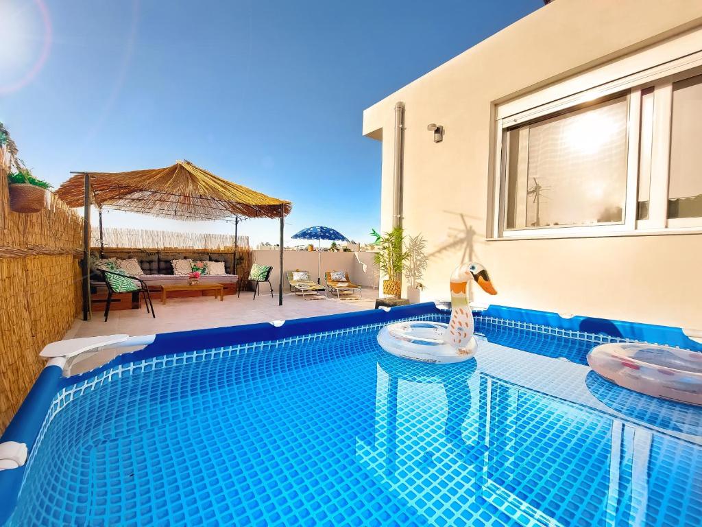 a swimming pool in front of a house at Holiday House Heraklion & Roof Garden in Heraklio