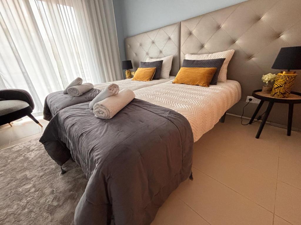 1 dormitorio con 2 camas y toallas. en Royal Golf By ELISA Cabanas Tavira Conceição en Conceição