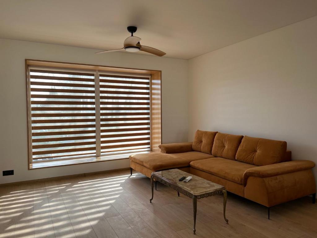a living room with a couch and a window at Rekvila in Šiauliai