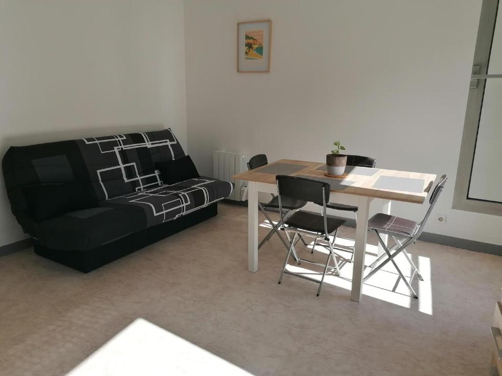 a living room with a table and a couch at Appartement-Vierzon-centre in Vierzon